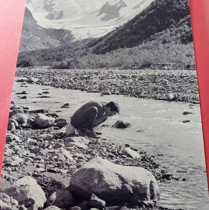 a picture of someone washing their face in a stream