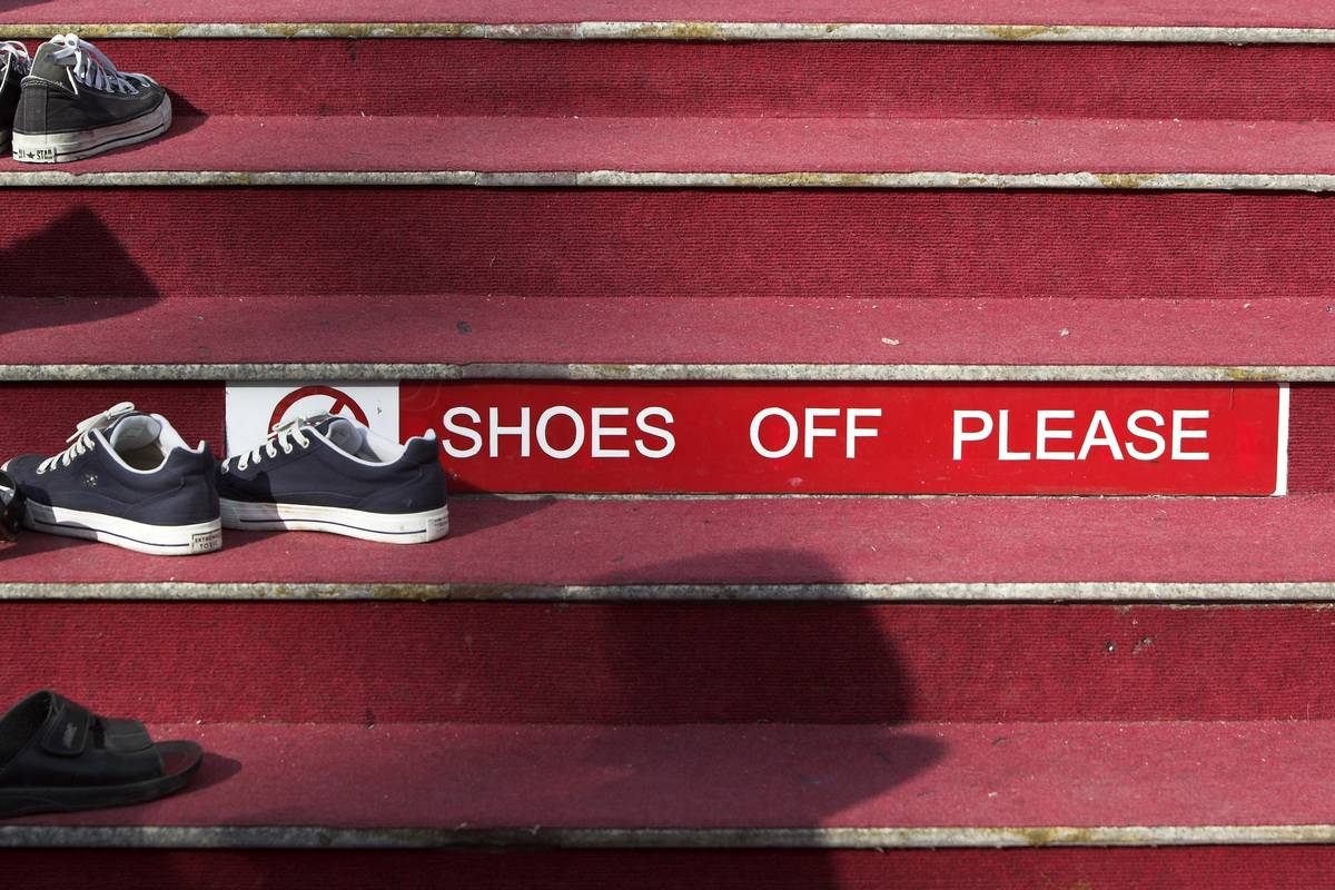Shoes and Remove Shoes sign on carpet steps Wat Chalong Phuket Thailand