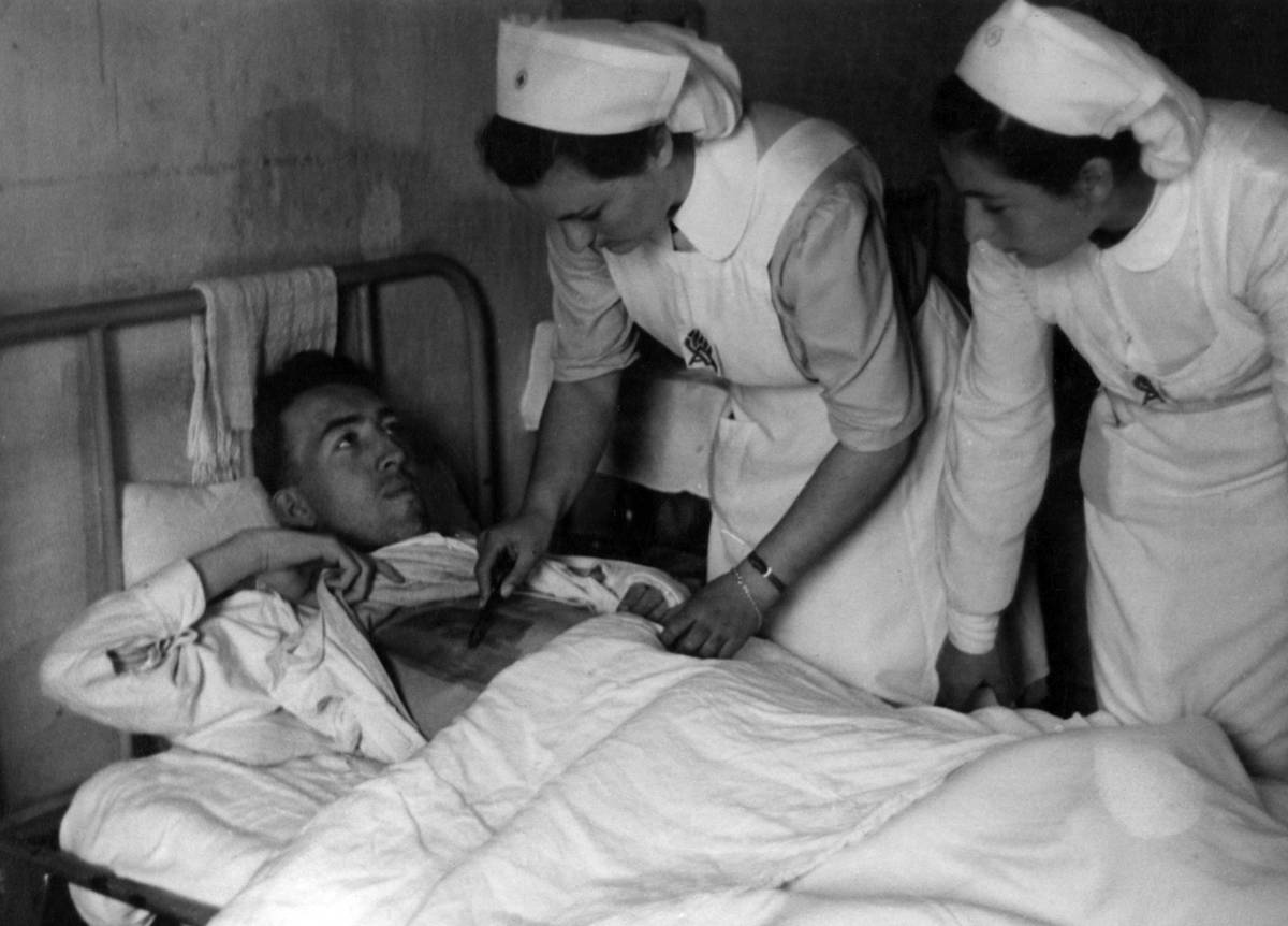 Red Cross nurses of the Women's Auxiliary Service taking care of a patient