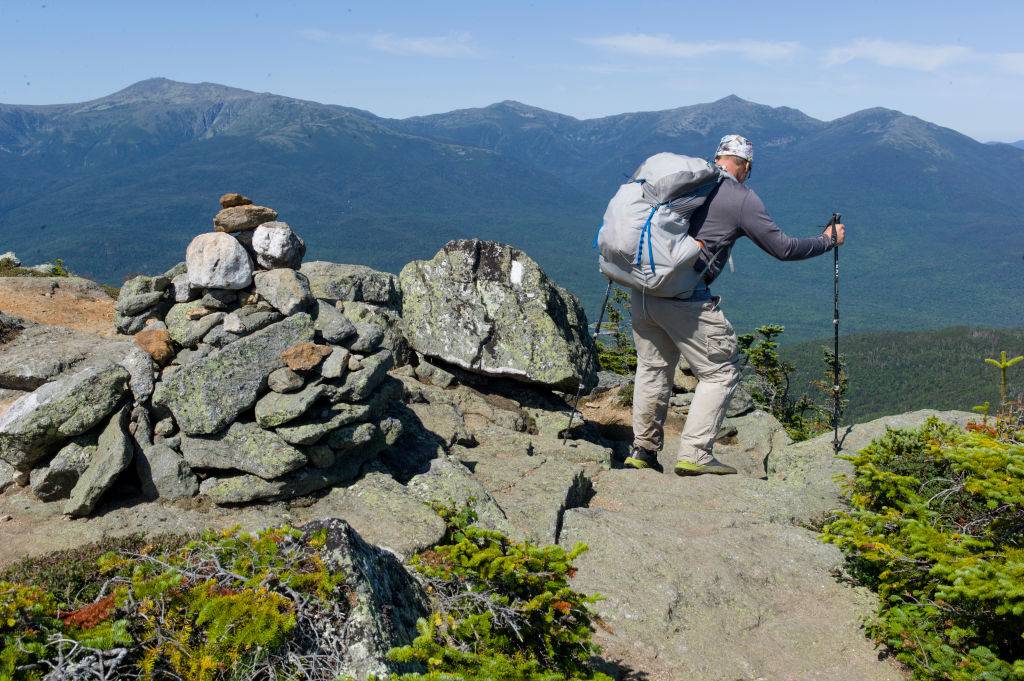 a backpacker looking down a mountain on the Pemigewasset Wilderness Loop in new hampshire