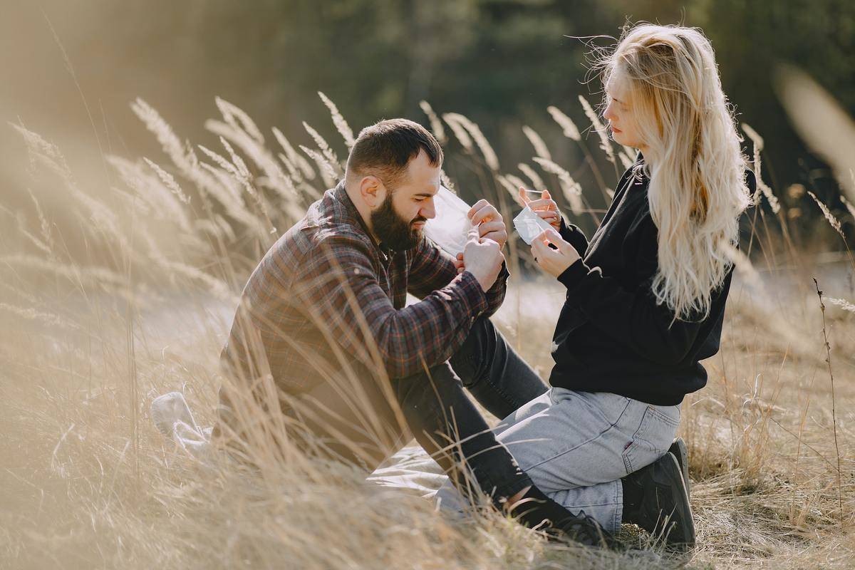 couple kneeling in field serious