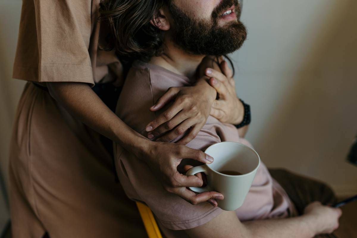 woman standing behind man with coffee