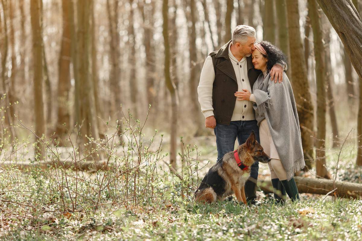 older ocuple in woods with dog