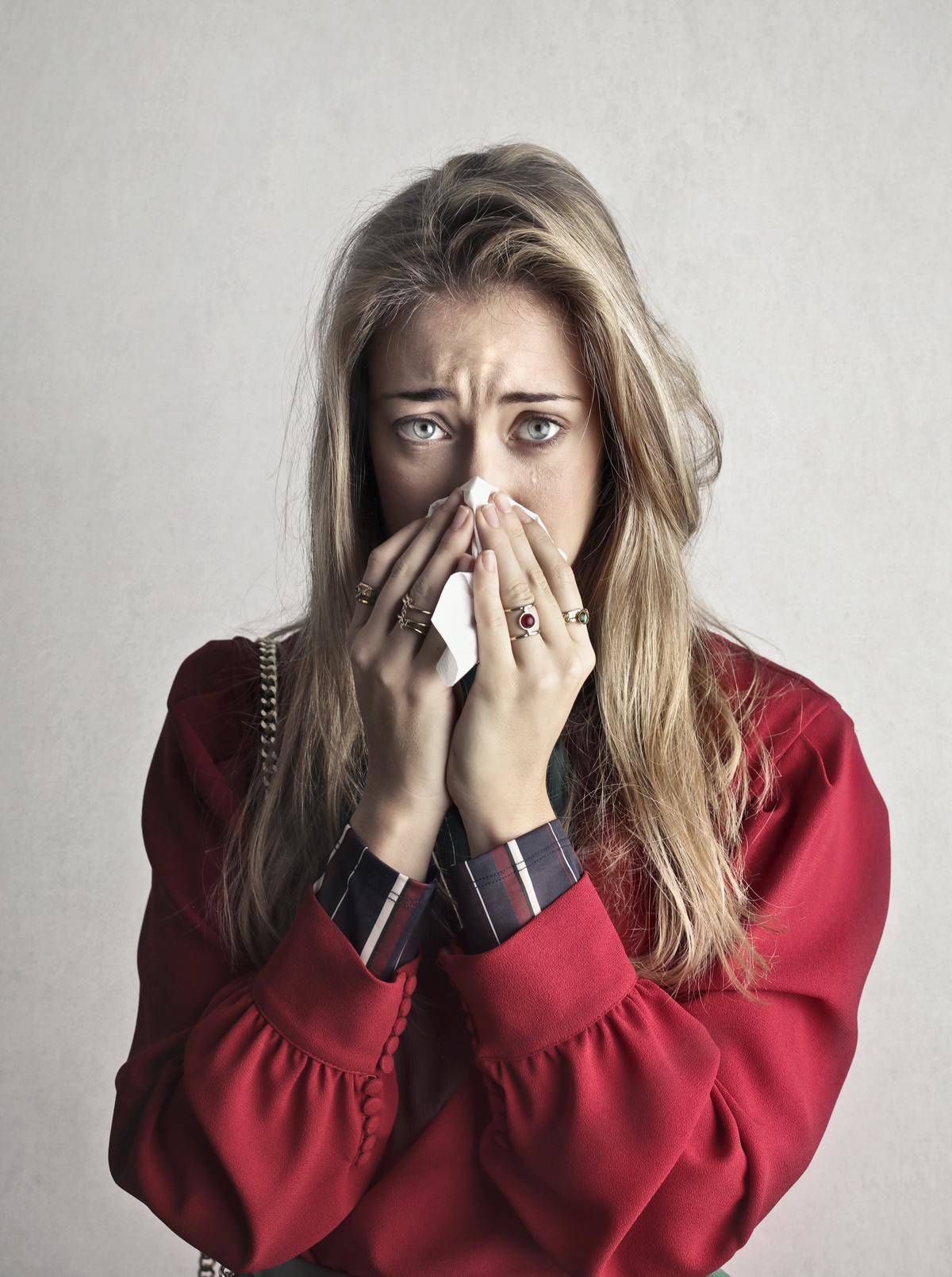 photo-of-crying-woman-in-red-long-sleeve-shirt-blowing-her