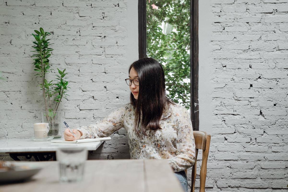woman sitting in cafe writing