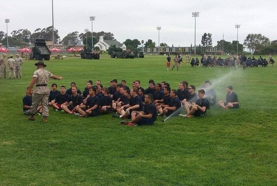 boy sitting in direct line of sprinkler