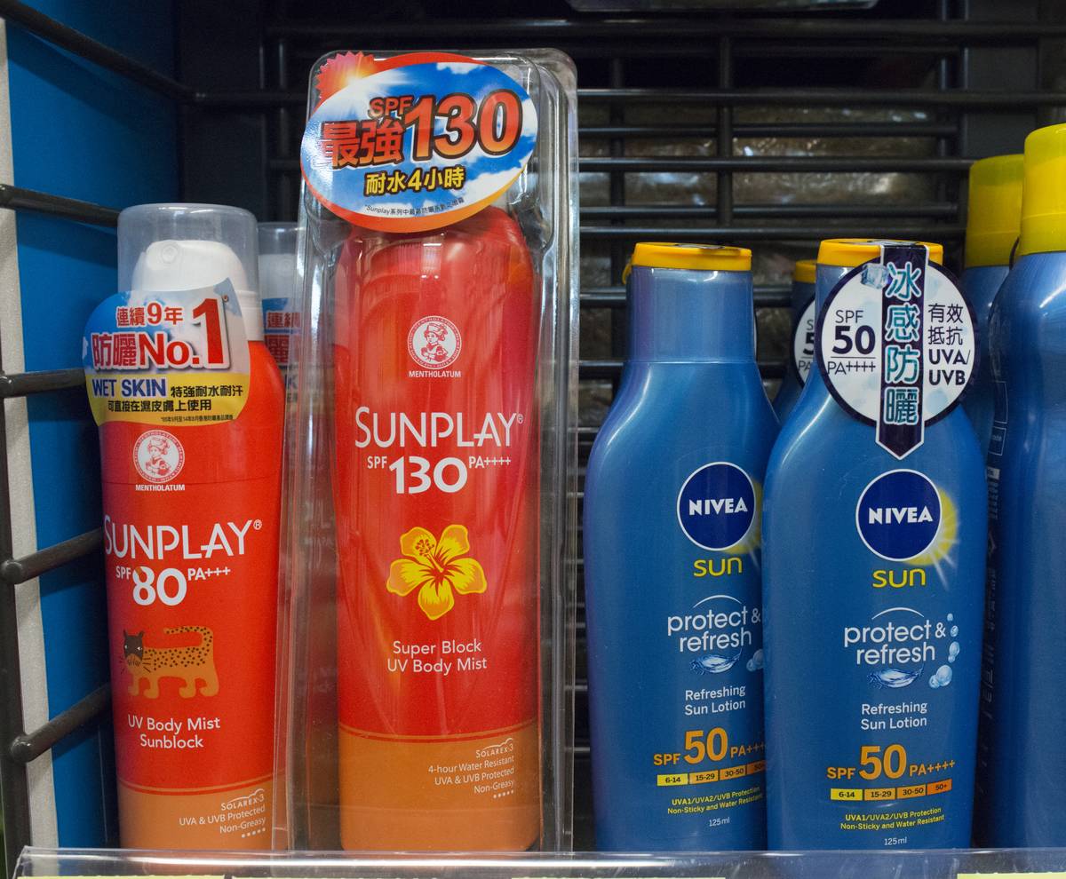 Various sunscreen bottles with an SPF of 50 or above sit on a shelf. 