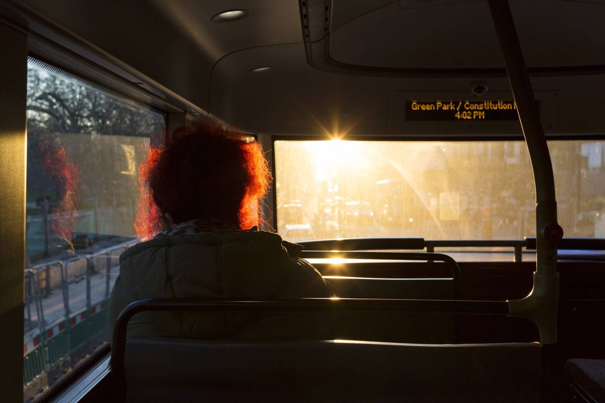 The sun shines through the window of a bus.