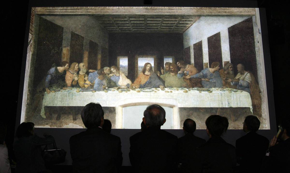 People look at a projection of The Last Supper.