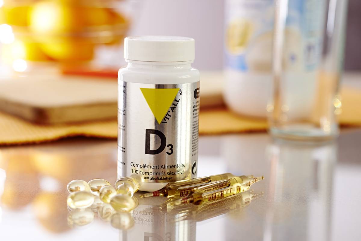 Vitamin D3 supplements are next to a bottle.