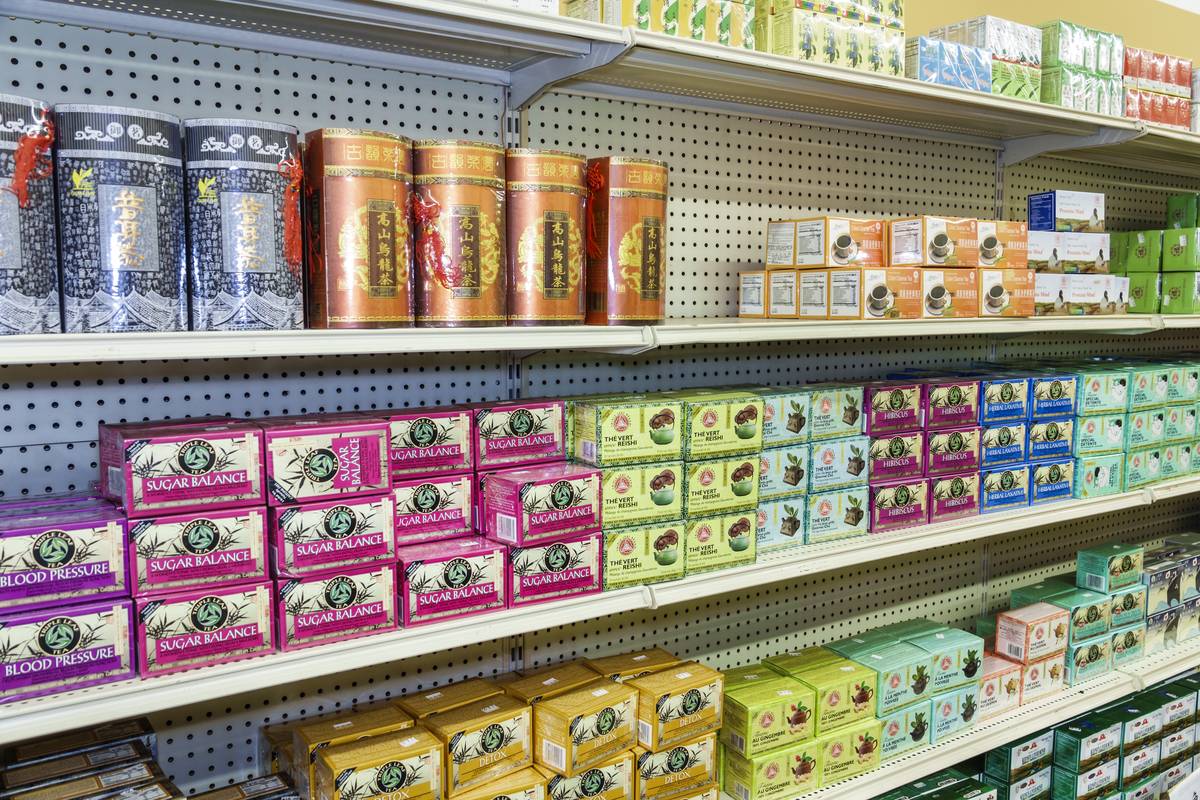 Various medicinal teas sit on a supermarket shelf.