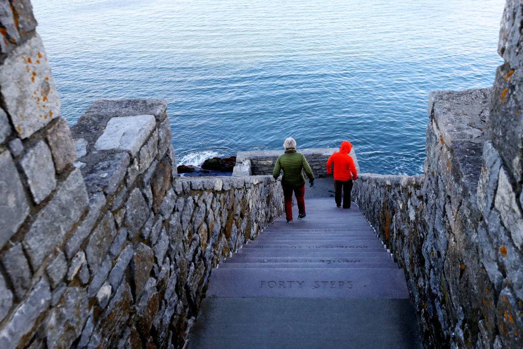 people walking down steps near the ocean in Newport, Rhode Island