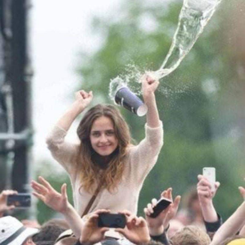 a cup in mid air coming at a girl at a concert