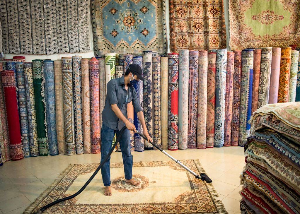 A Moroccan rug dealer cleans a carpet at a shop in the city of Sale, north of the capital Rabat, on June 3, 2020, during the novel coronavirus pandemic. - Artisans in Morocco have been starved of income for almost three months because of the COVID-19 pandemic. The crafts industry represents some seven percent of GDP, with an export turnover last year of nearly 1 billion dirhams ($100 million).