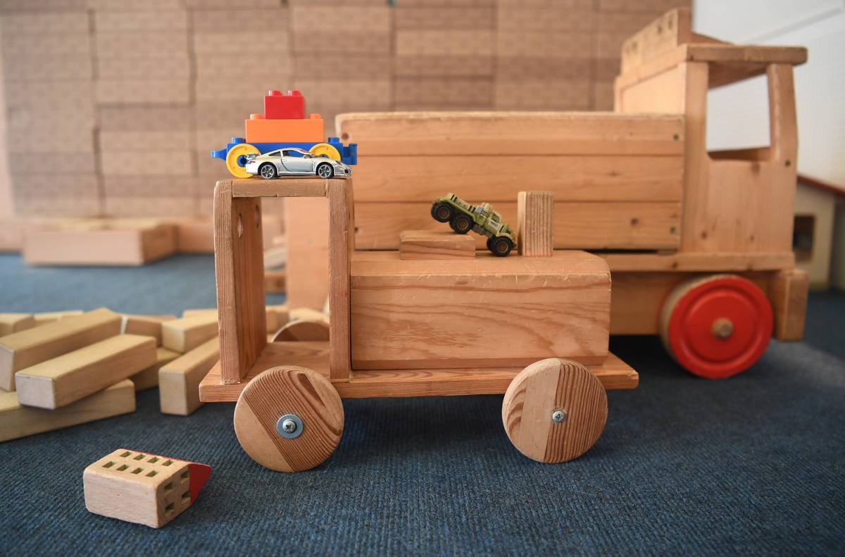 Wooden toys and toy cars are pictured.