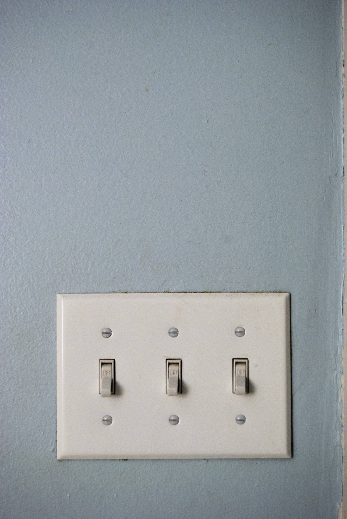 Three light switches are on a wall.