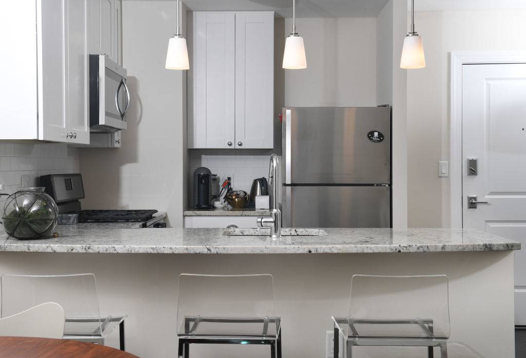 WASHINGTON, DC - NOVEMBER 12: Laura Kiker's kitchen has granite counter tops, stainless steel appliances and pendant lighting November 12, 2017 in Washington, DC. Kiker's building previously was a section of Specialty Hospital Capitol Hill. (