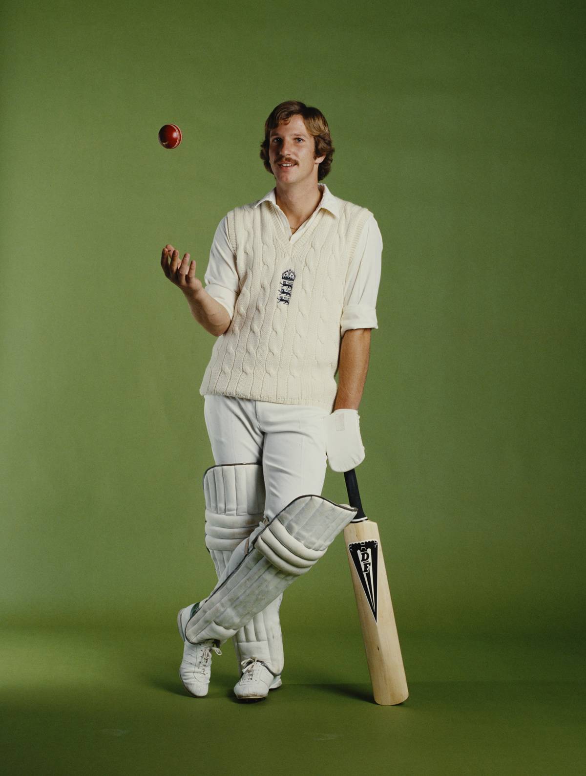 Ian Botham tosses up a ball during a photoshoot.