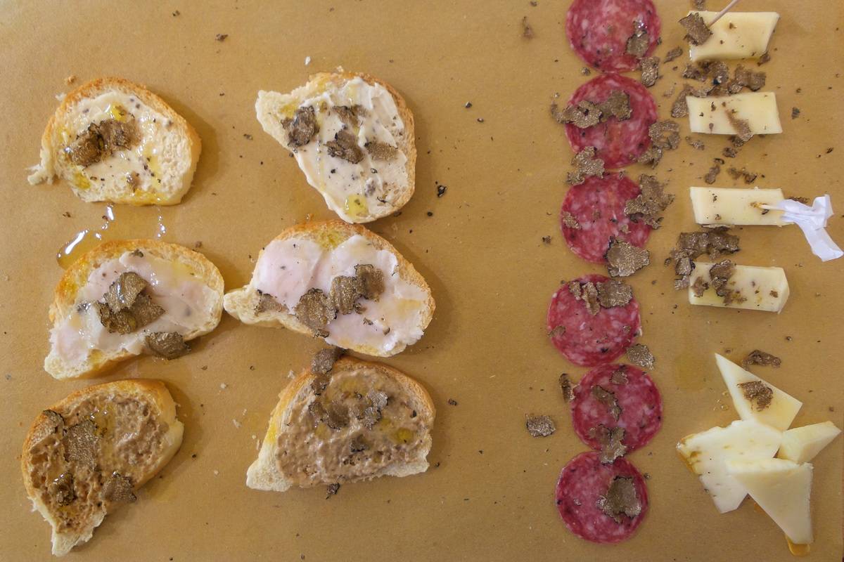 Meats, breads, and cheeses lie out in a meat platter in Tuscany.