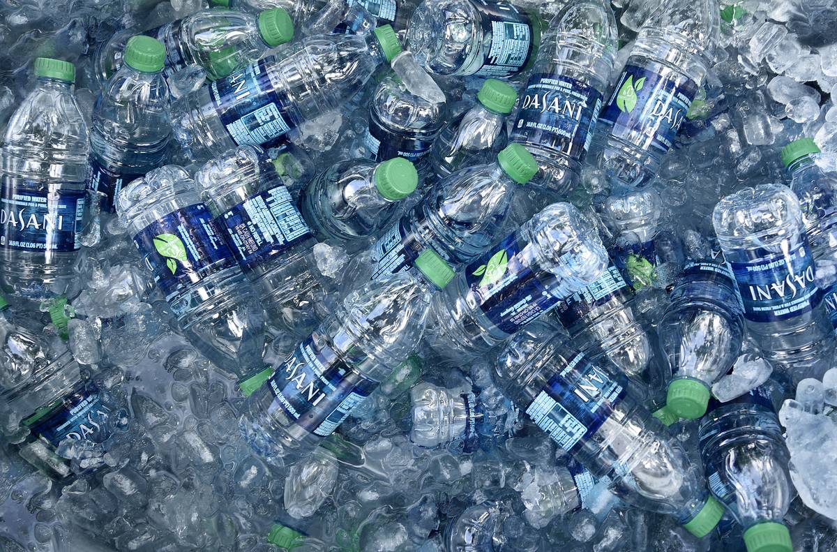 Plastic water bottles lie in a bucket with ice.