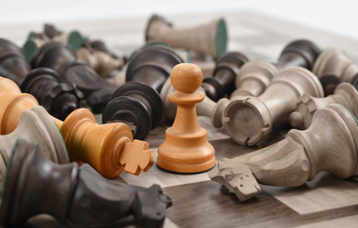 chess pieces all knocked over except for pawn