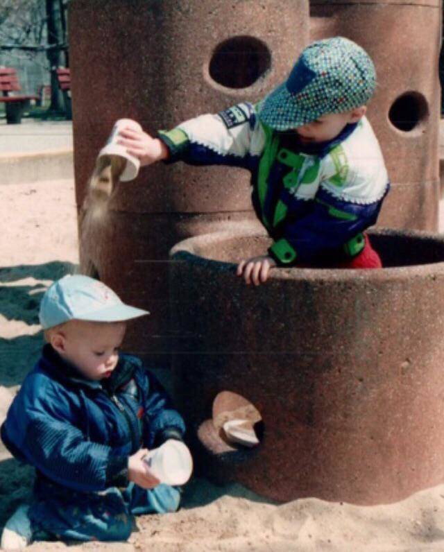 brother dumping sand on younger brother