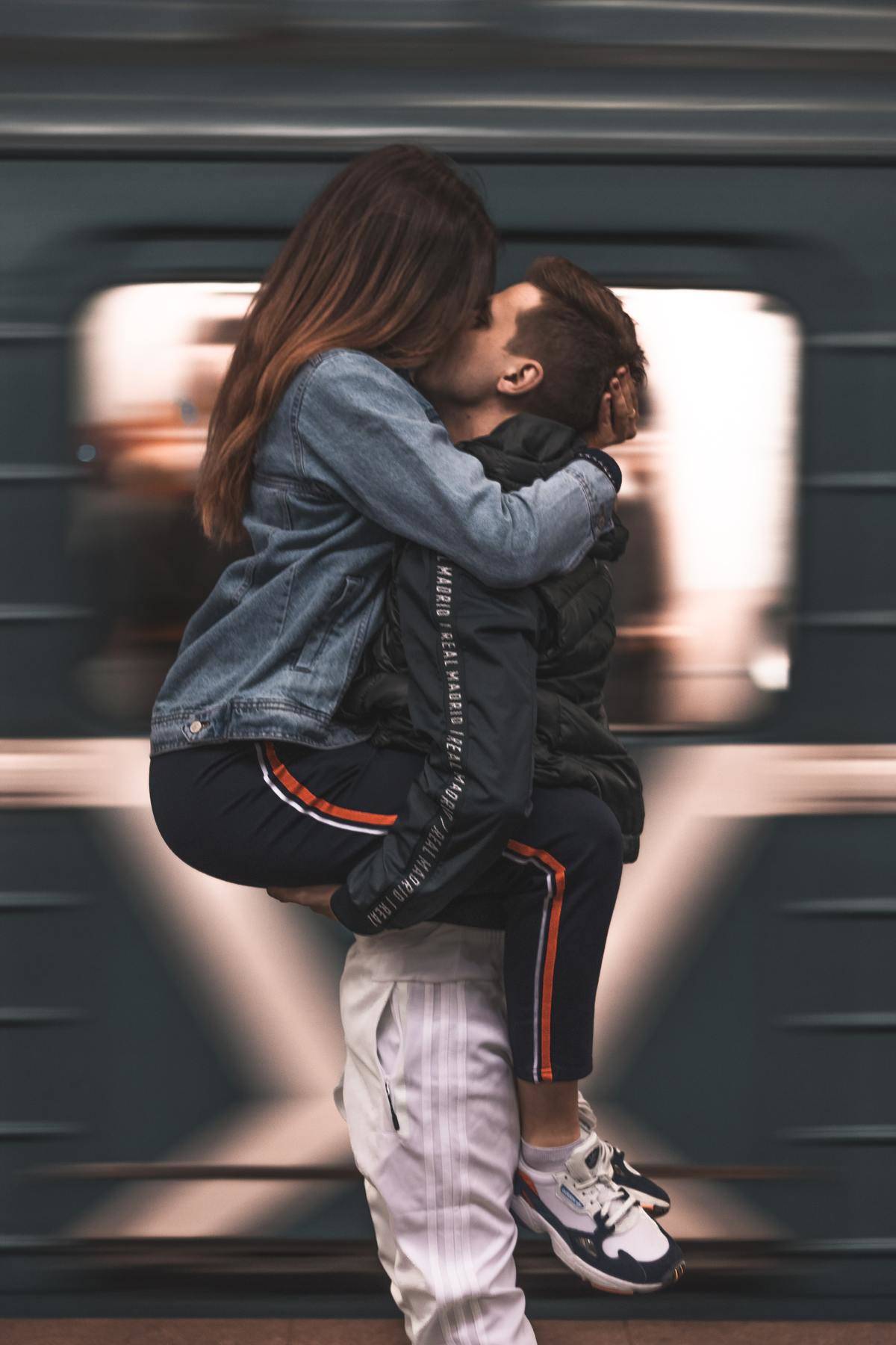 couple kissing in front of a moving train