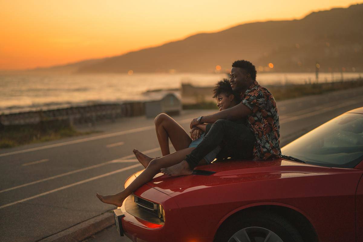 couple sitting on top of a car