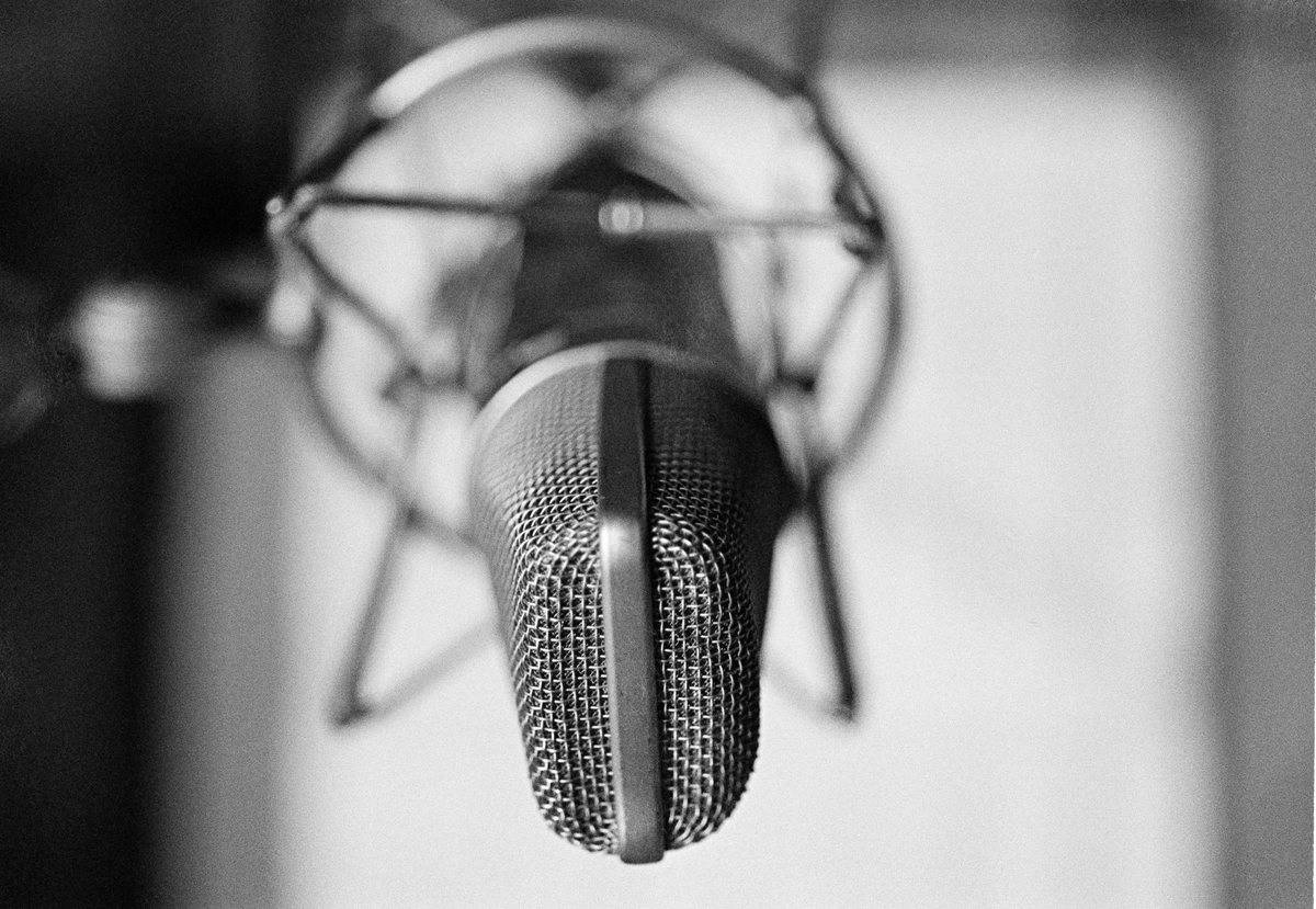 General view of a condenser microphone in a shock mount in a recording studio, circa 1980