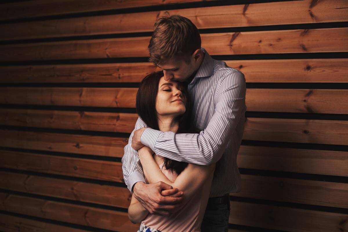 guy kissing girl on the forehead