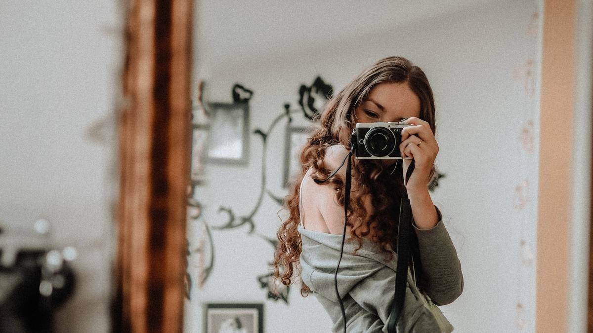 woman taking photo of self in mirror