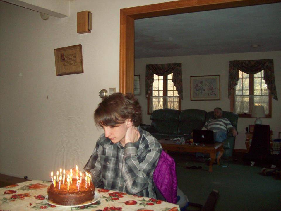 child alone in front of birthday cake with candles