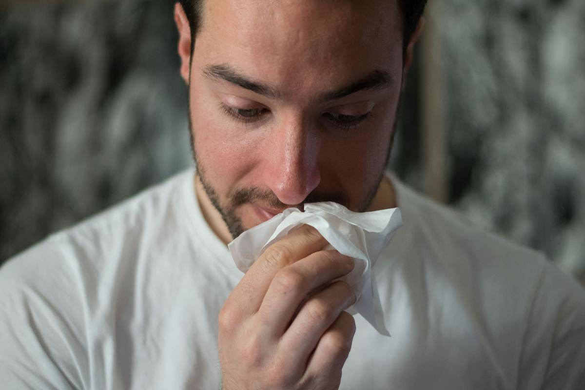 sick man blows his nose