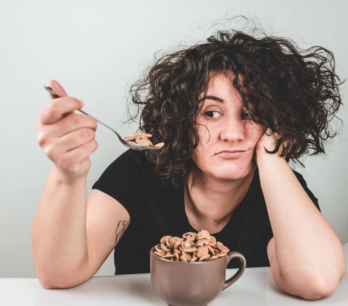 woman looks unimpressed with cereal bowl
