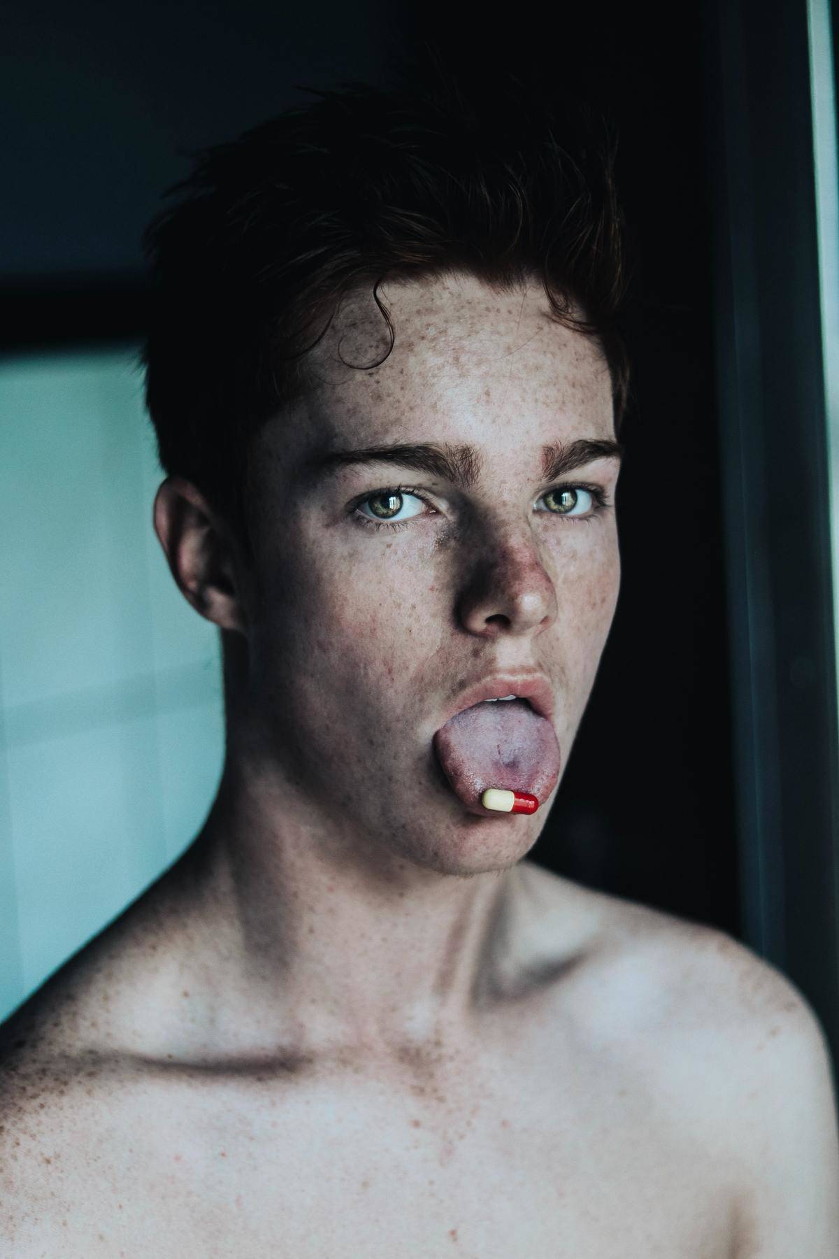 man with pill on his tongue