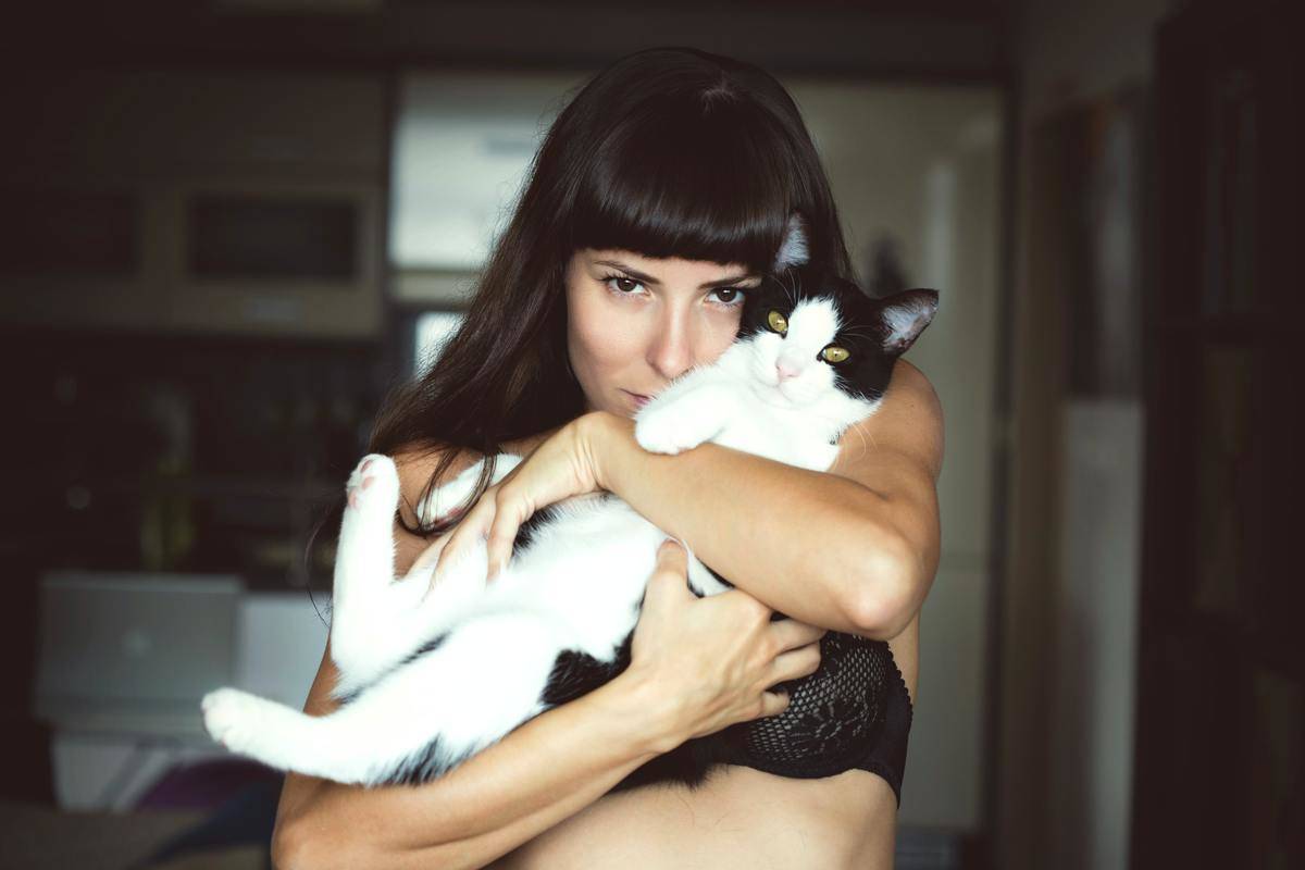woman holds cat close to her
