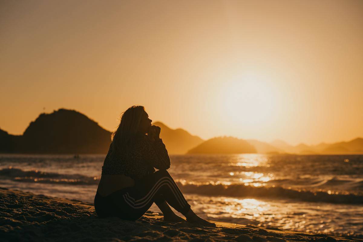 silhouette of woman on beach at sunset