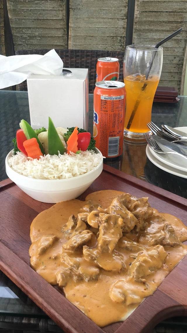 Curry on a chopping board with rice in a bowl