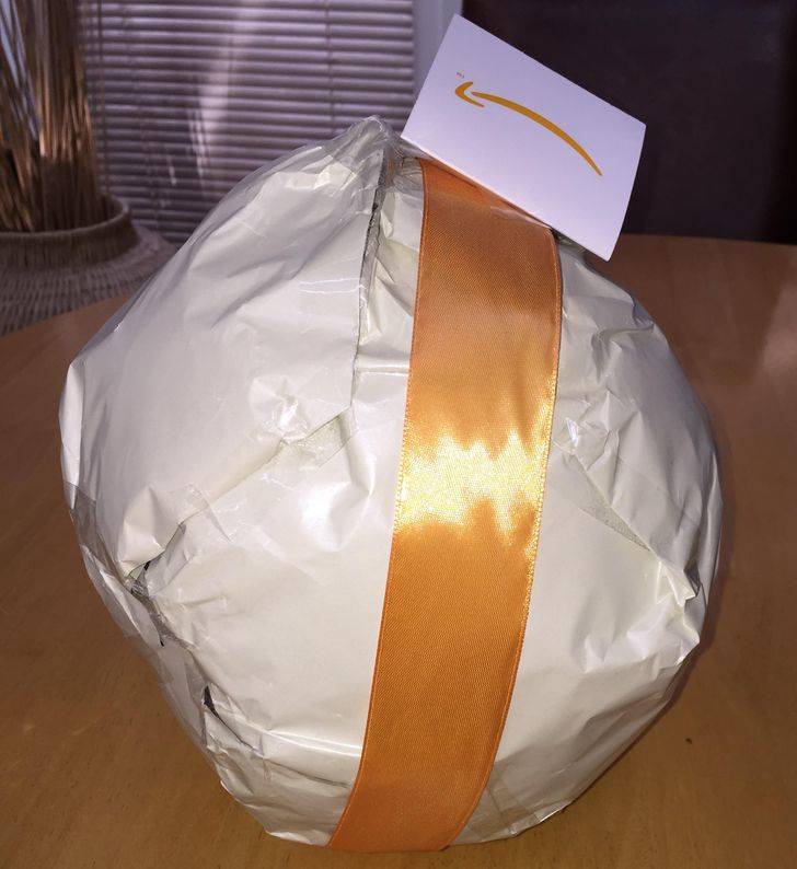 amazon package wrapped in generic plastic with orange ribbon