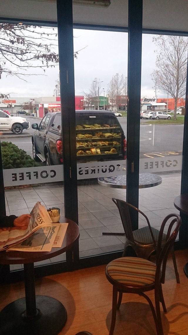 reflection of cafe in window looks like car is carrying it