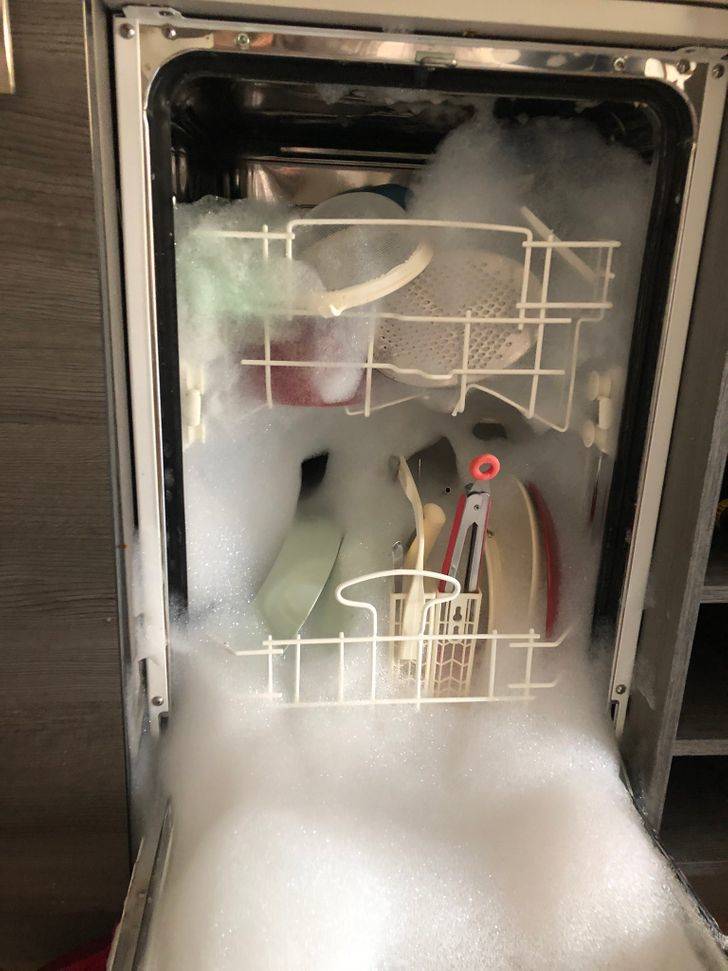 Dishwasher is opened to reveal a ton of suds filling it