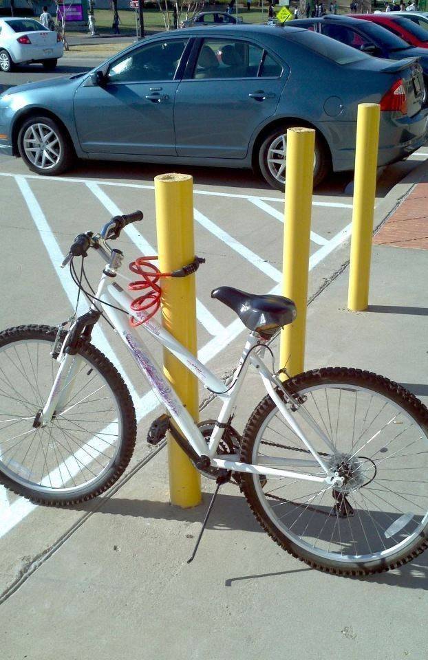 Person locked bike to a bollard, where the lock can easily be slid up and off.