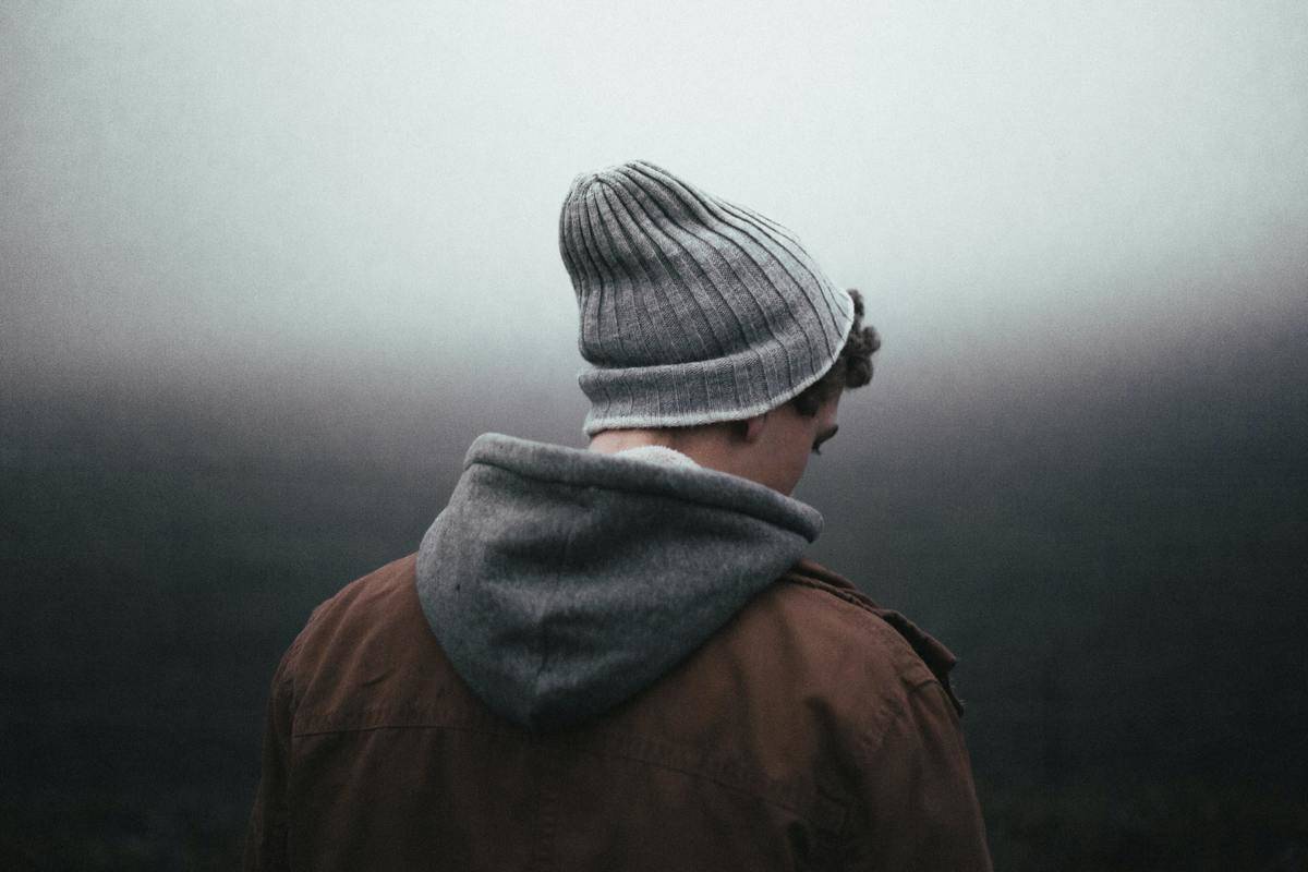 man in beanie and jacket in the fog