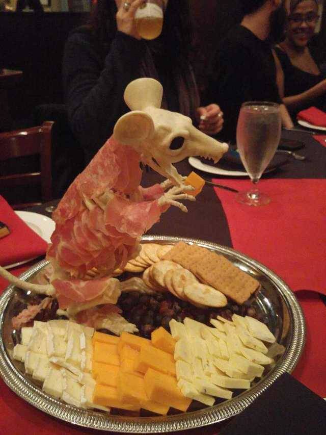 charcuterie with meat served on fake mouse skeleton