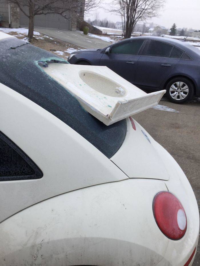 A sink breaking through a car's rear window