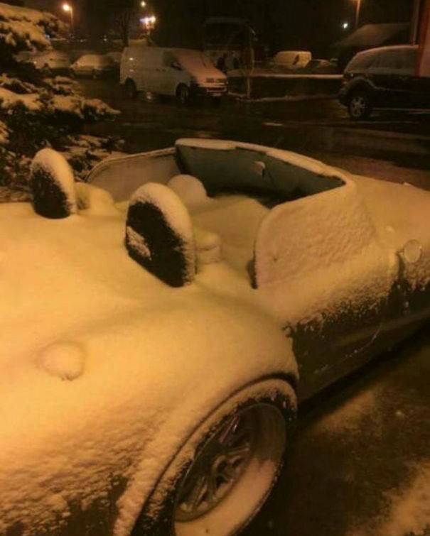 Snow all over interior of convertible car.