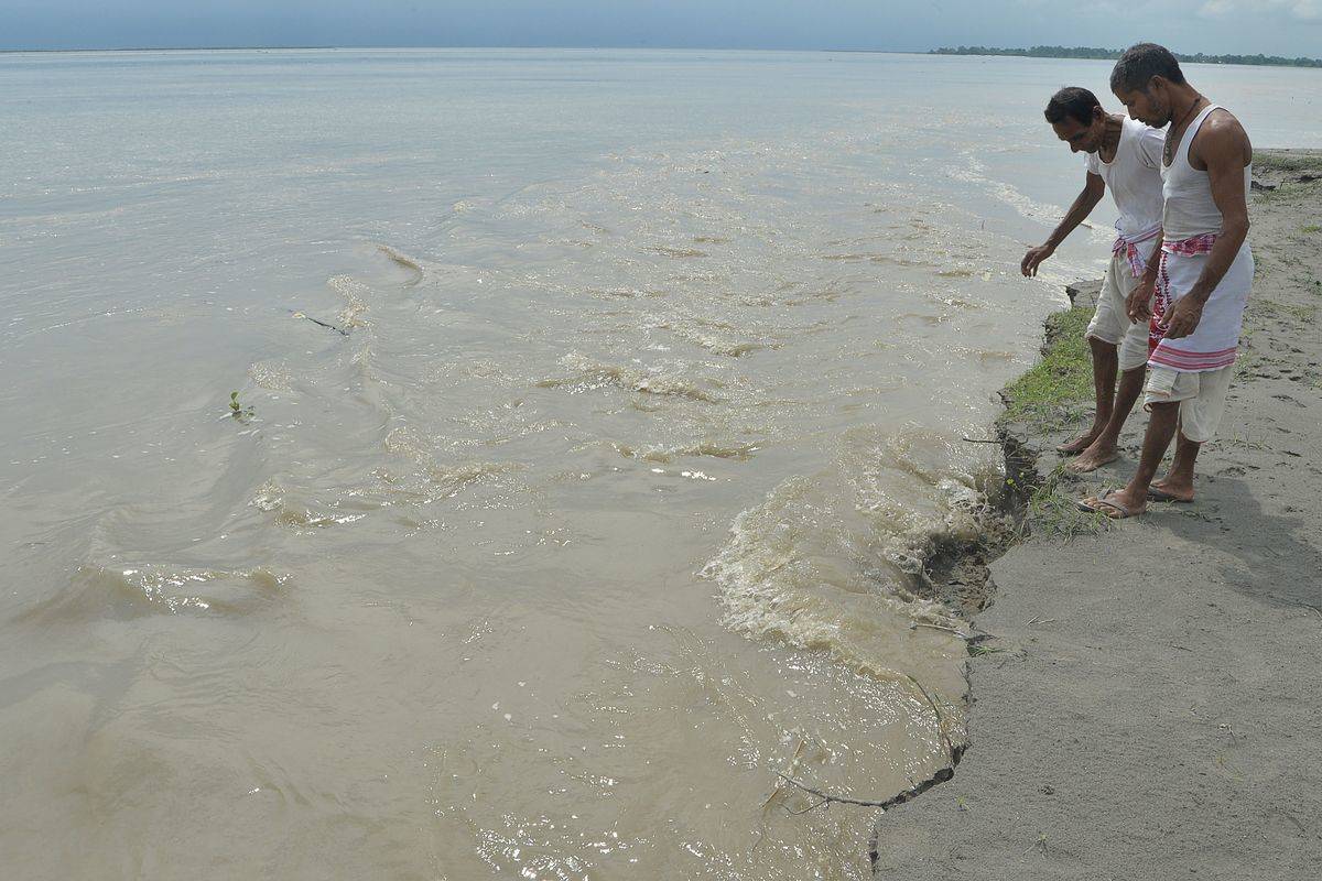 Two men stand at the shore of the Amazon river.