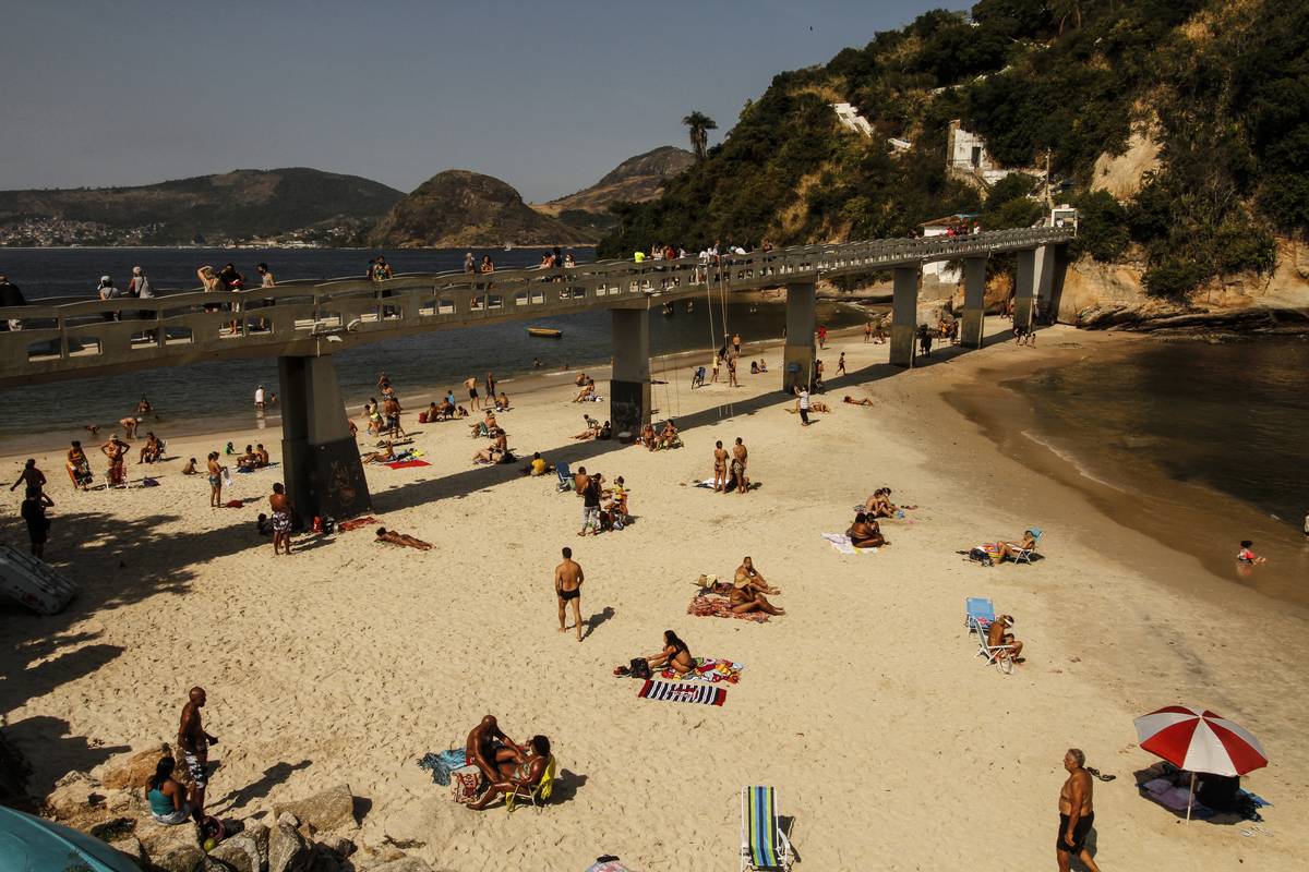 Beachgoers enjoy the weather underneath the bridge at Boa Viagem Beach, Brazil.