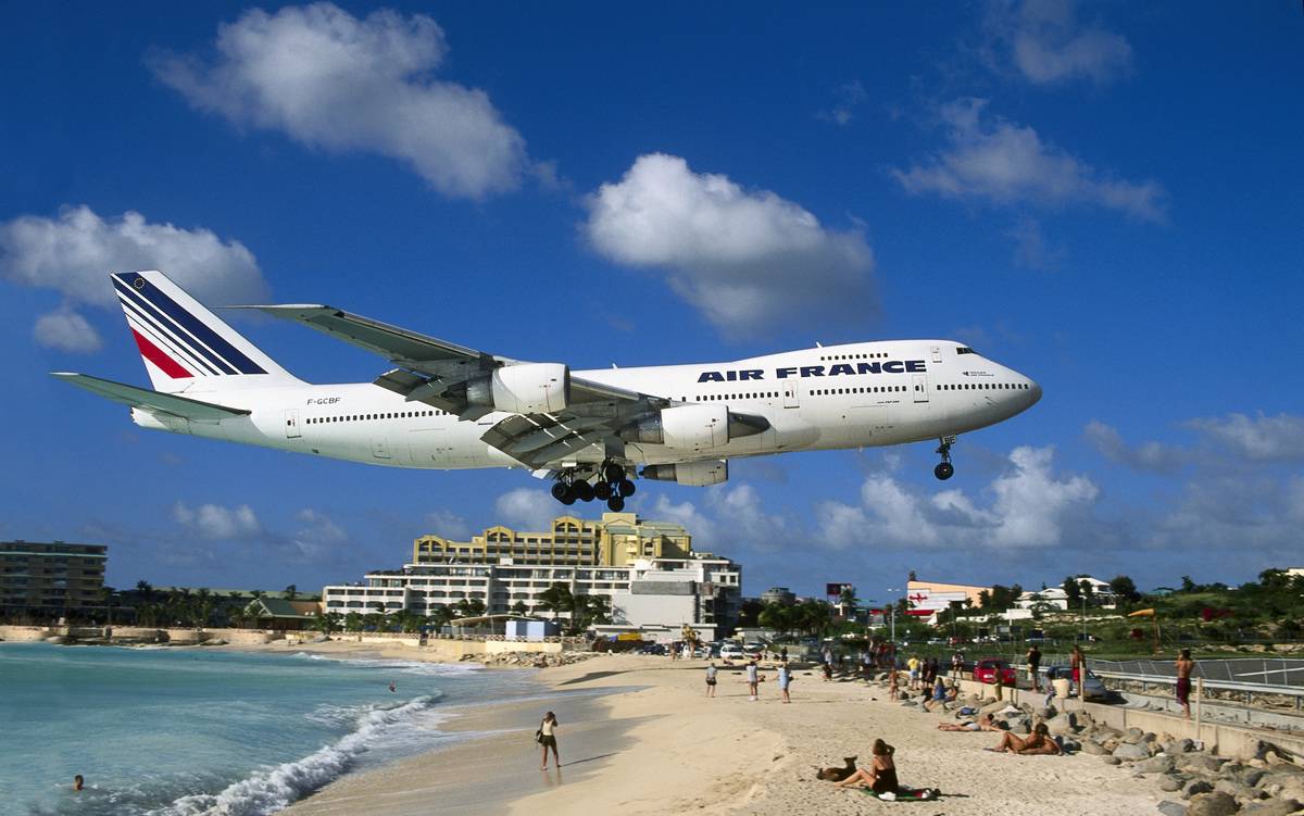 A French airliner flies directly above Maho Beach in the Caribbean.