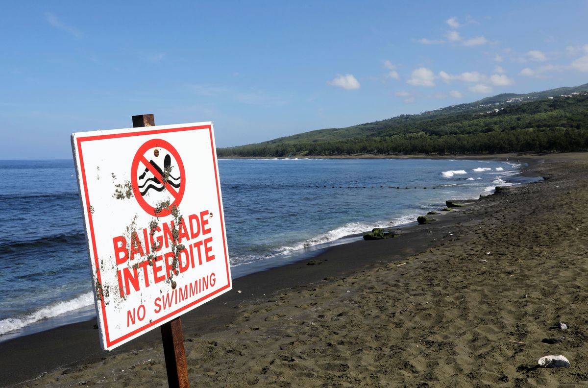 A sign dissuades visitors from swimming in the waters of Réunion Island, France.